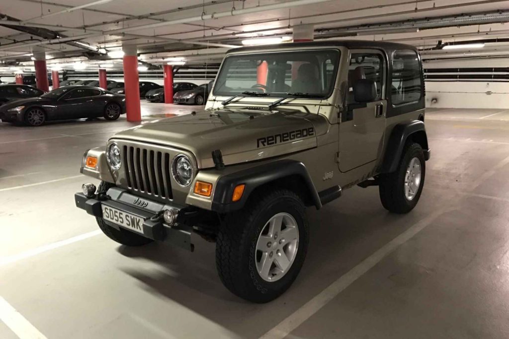 A gold Jeep Wrangler Renegade edition with a hardtop, parked in an underground car park