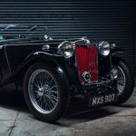 A classic black MG TC roadster parked in a garage - the type of vintage vehicle often protected by laid up insurance cover.