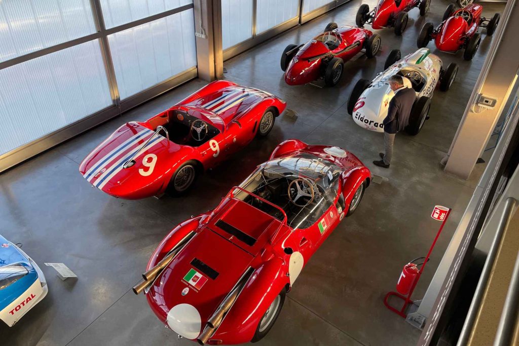 An overhead view of the Maserati Museum's racing gallery, showing multiple classic cars