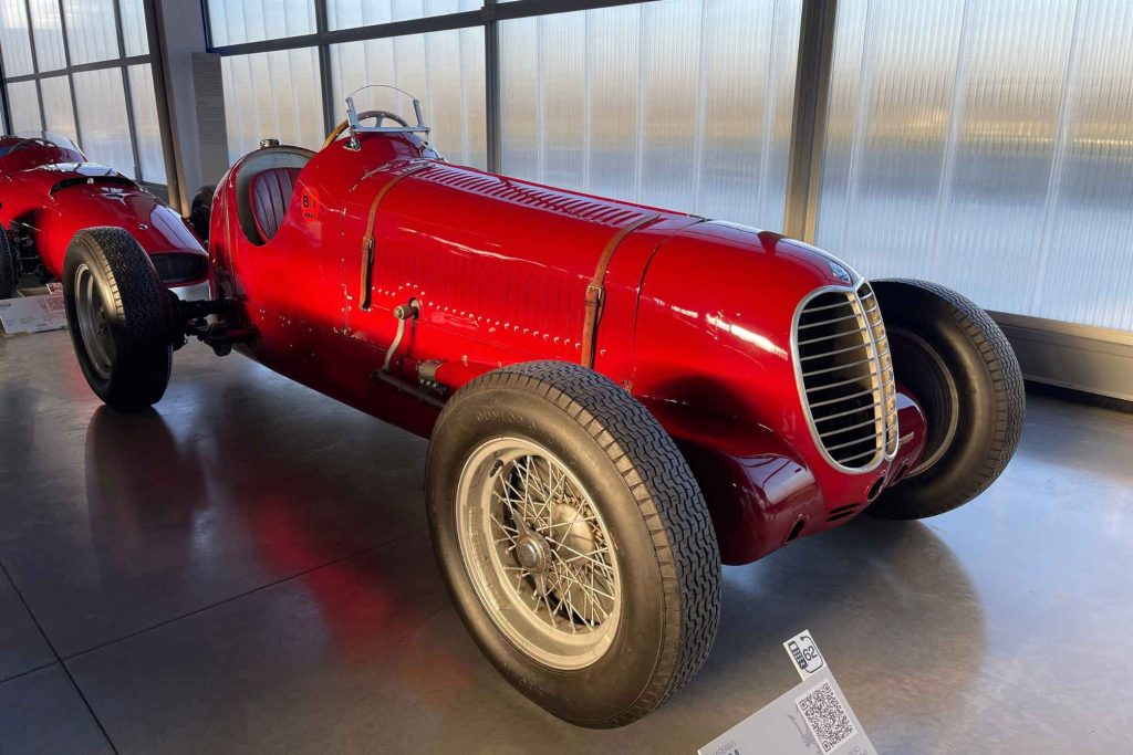 A pre-war red Maserati single-seater Grand Prix car displayed in the Maserati Museum.