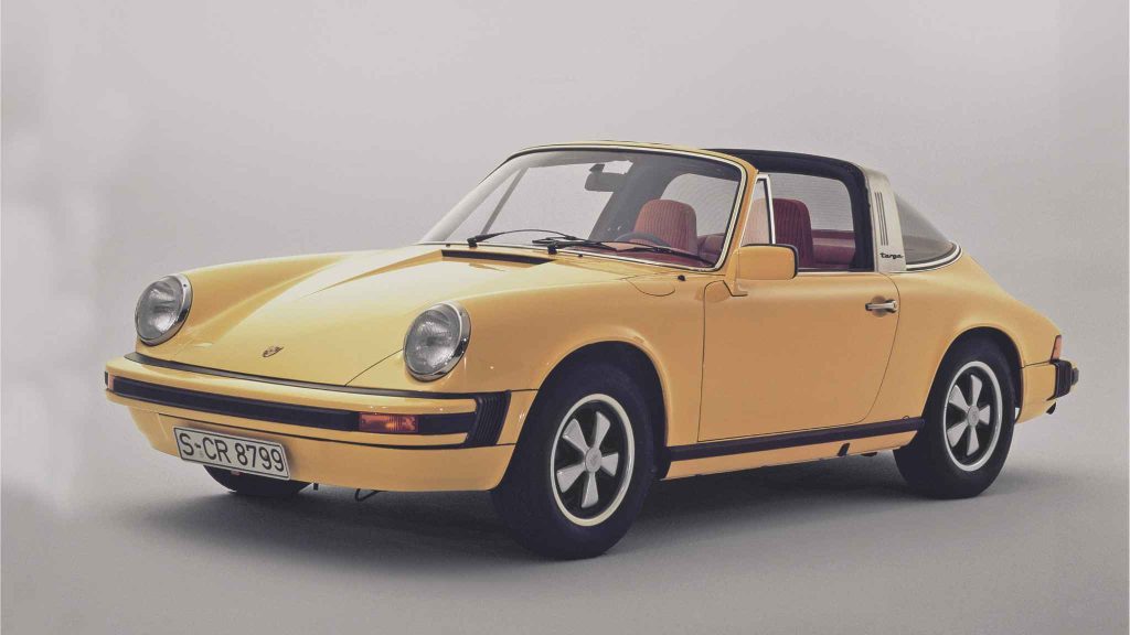 Yellow Porsche 911 Targa with red interior photographed in a studio against a grey background