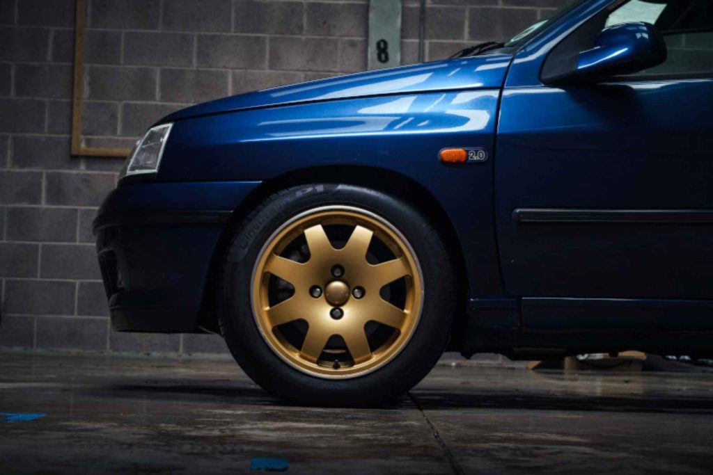 Front wheel detail of a blue Renault Clio Williams parked in a garage - the type of vehicle often protected by laid up insurance cover.