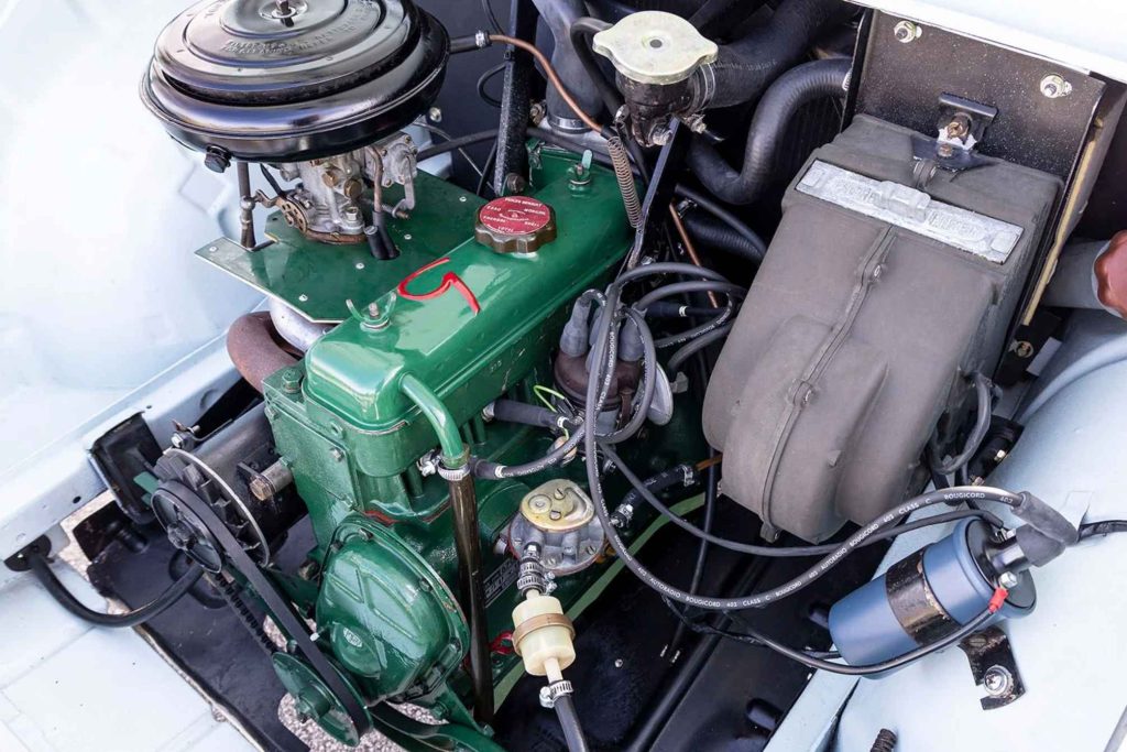 Engine bay of a Renault Floride showing the compact green-painted four-cylinder engine with round air filter, carburettor, and period-correct ancillaries including a Bougicord ignition system.