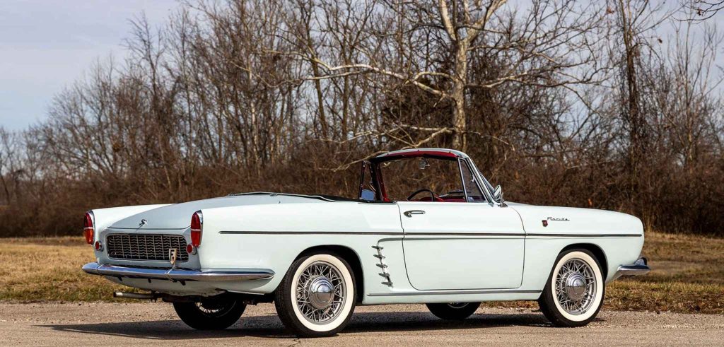 Rear three-quarter view of the Renault Floride cabriolet with the roof fully lowered, revealing the red interior, chrome tail finishings, and "Floride" script badge on the rear quarter panel.