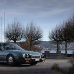 Front three-quarter view of a teal green Citroën CX D diesel saloon parked beside a Swiss lake