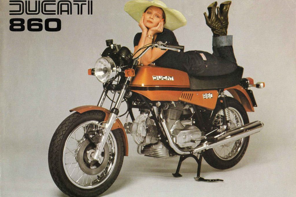 Vintage Ducati 860 advertisement with a woman in a wide-brimmed hat posing on an orange 1970s motorcycle