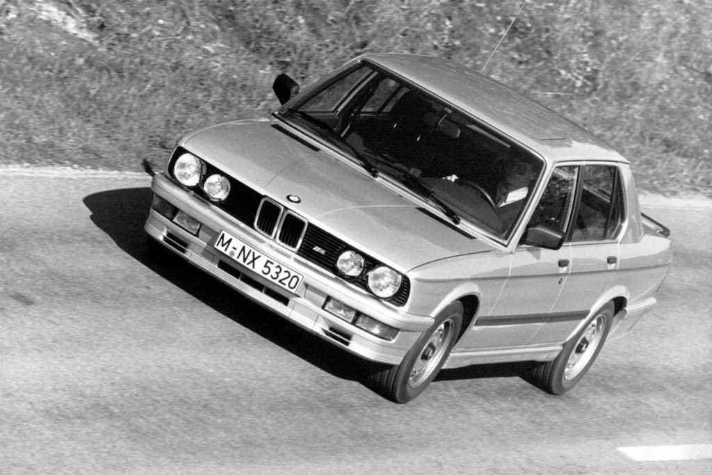 Black and white aerial front three-quarter press photograph of a silver BMW M535i E28 five-series saloon