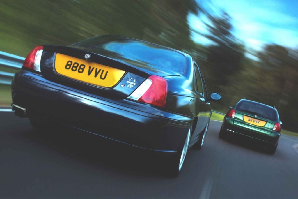 MG ZT saloon rear view in black with ZT in green following, action shot on road