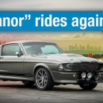 A grey Shelby GT500 Eleanor tribute Mustang with a man standing alongside making a rock gesture, and the headline "Eleanor rides again!"