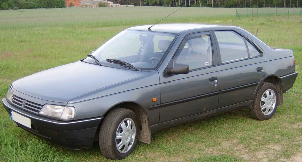 Front three-quarter view of a dark grey Peugeot 405 four-door saloon parked on grass