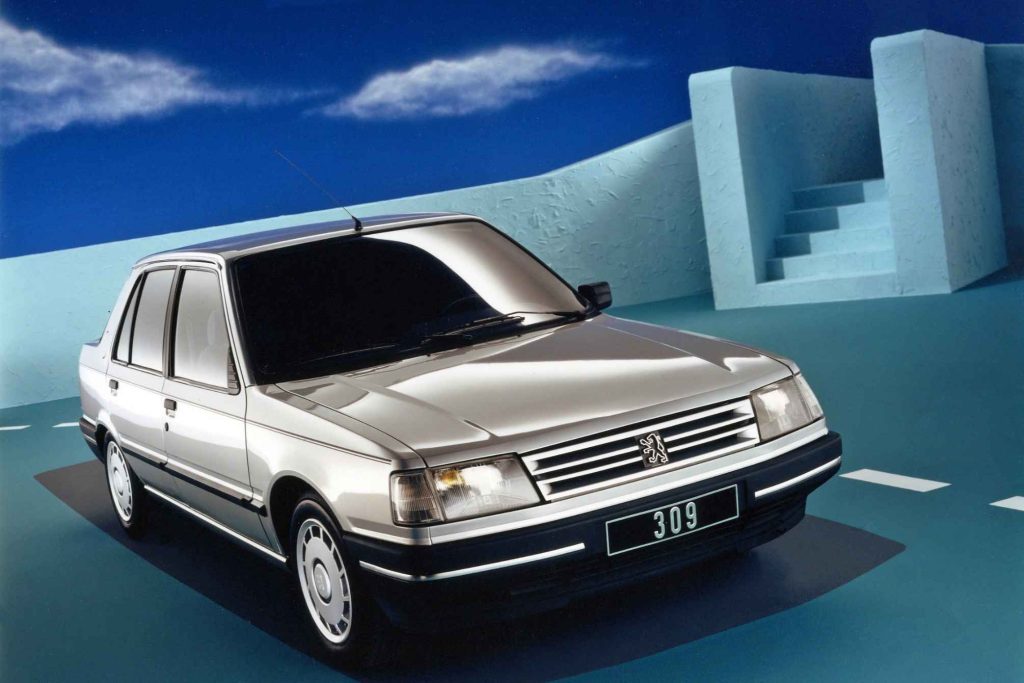 Peugeot 309 in silver, front three-quarter press studio shot with abstract architectural backdrop
