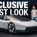 Two men stood next to a Tesla Roadster