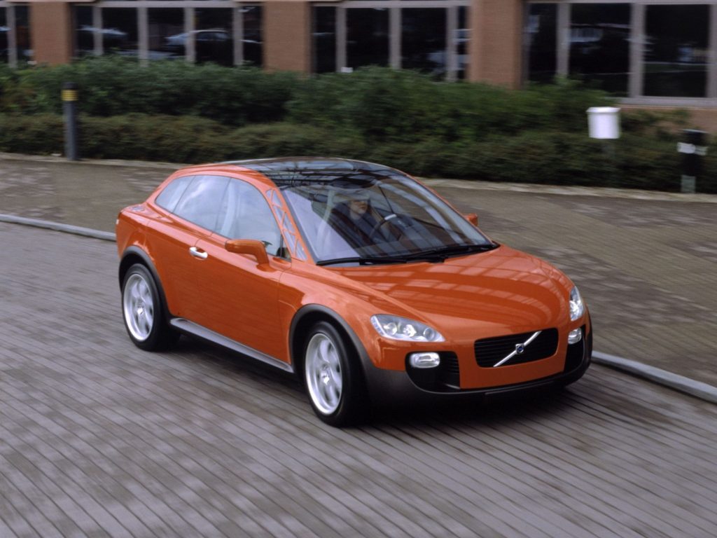 Orange Volvo SCC concept car driving past a brick building